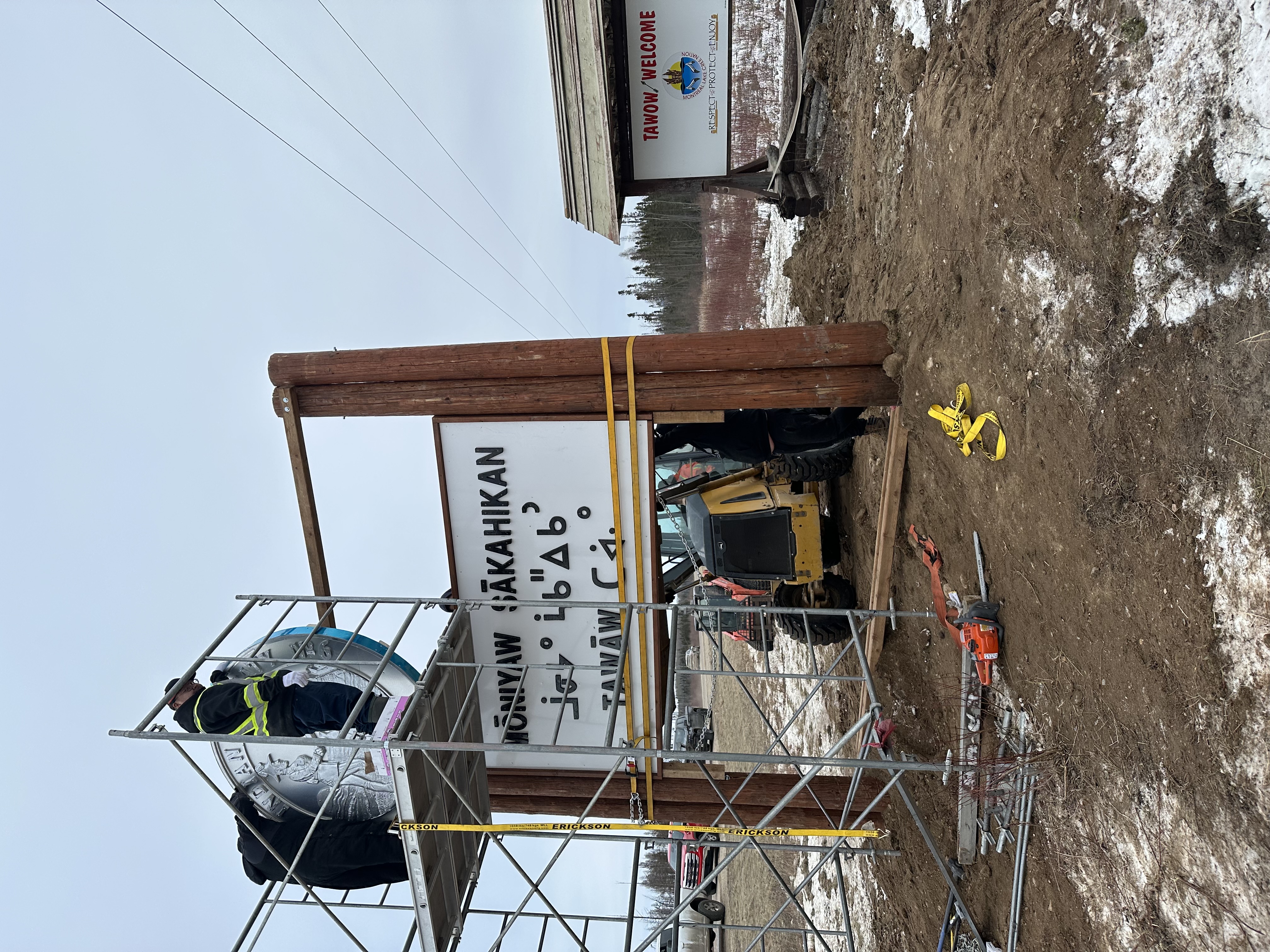 Moniyaw Sakahikan sign being assembled on scaffold with heavy timber headers and syllabic panel