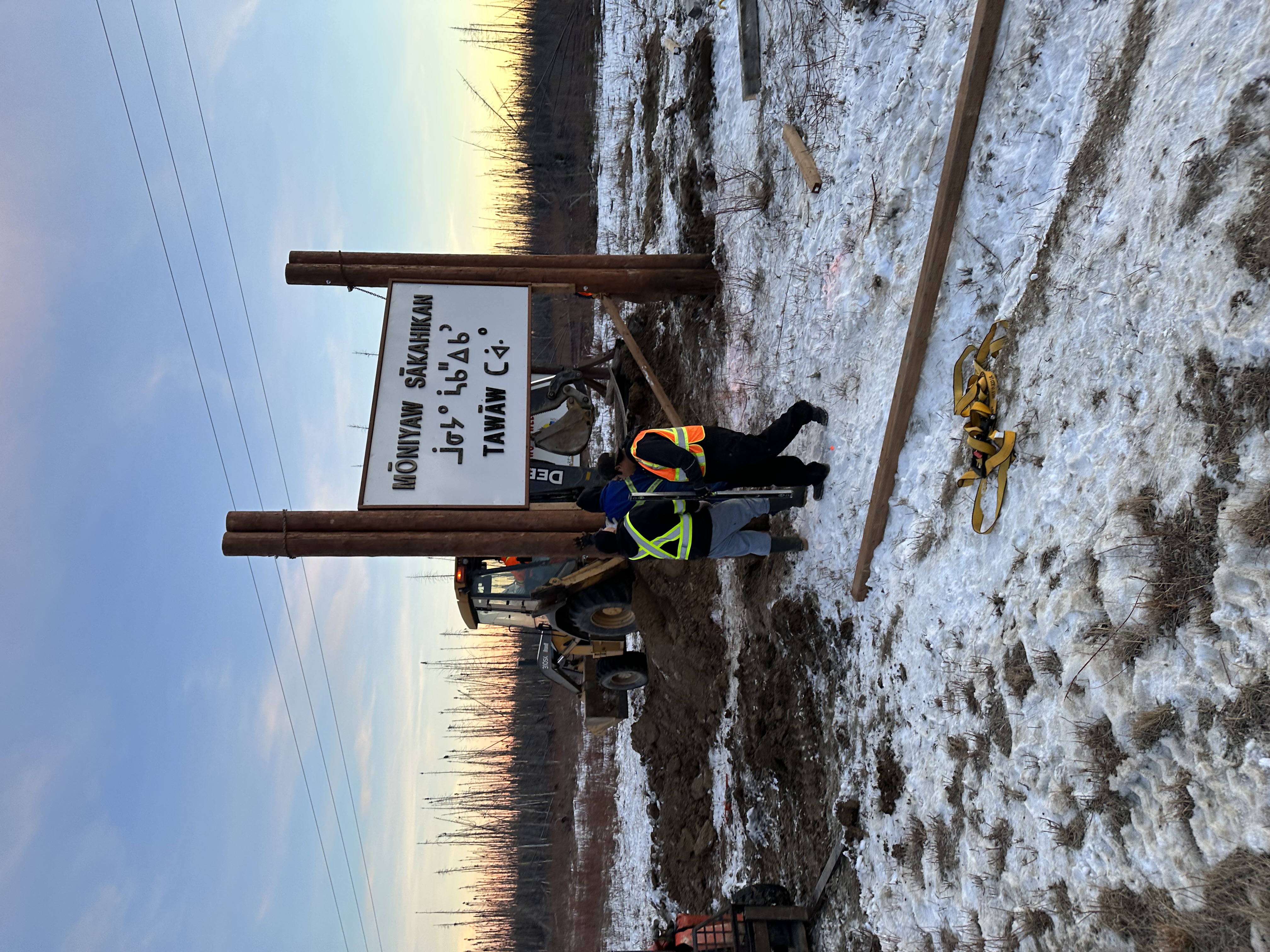 Moniyaw Sakahikan sign receiving final panel mount at golden hour