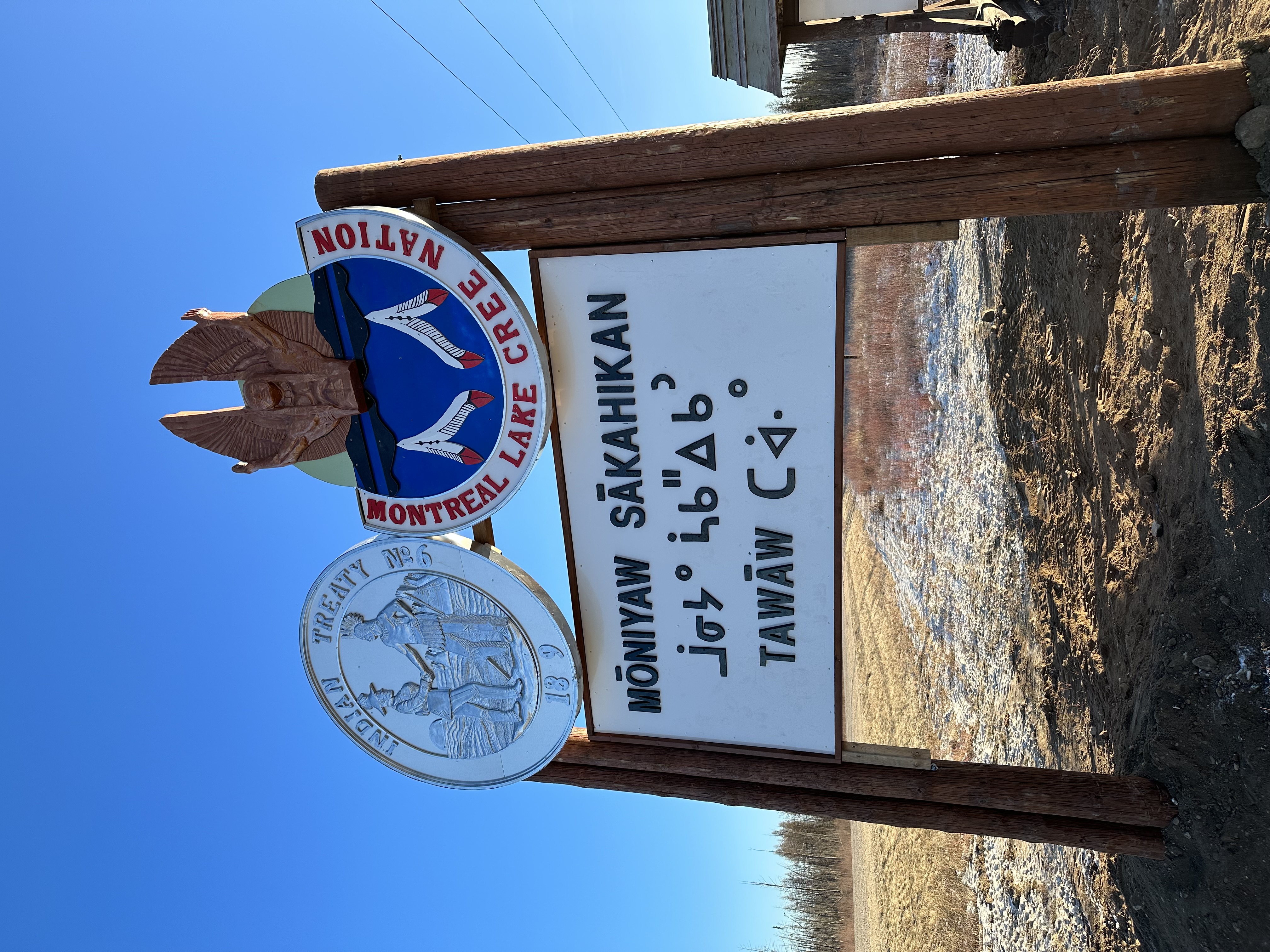 Montreal Lake Cree Nation Moniyaw Sakahikan sign close-up with Treaty 6 medallion and Montreal Lake Cree Nation crest in daylight