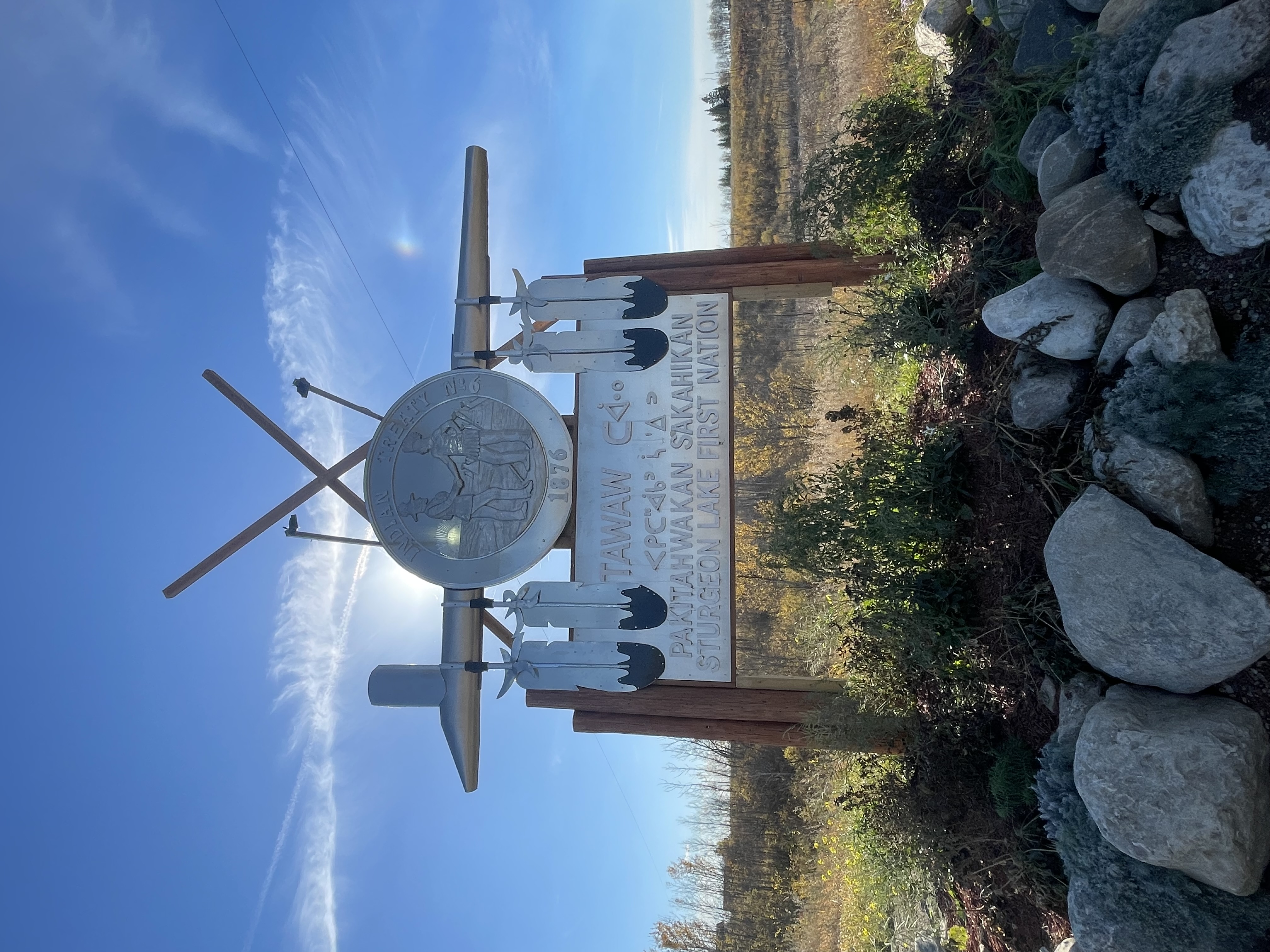Sturgeon Lake First Nation Pa Kwayahwakan Sakahikan entrance sign with Treaty 8 medallion, teepees and eagle feather detailing