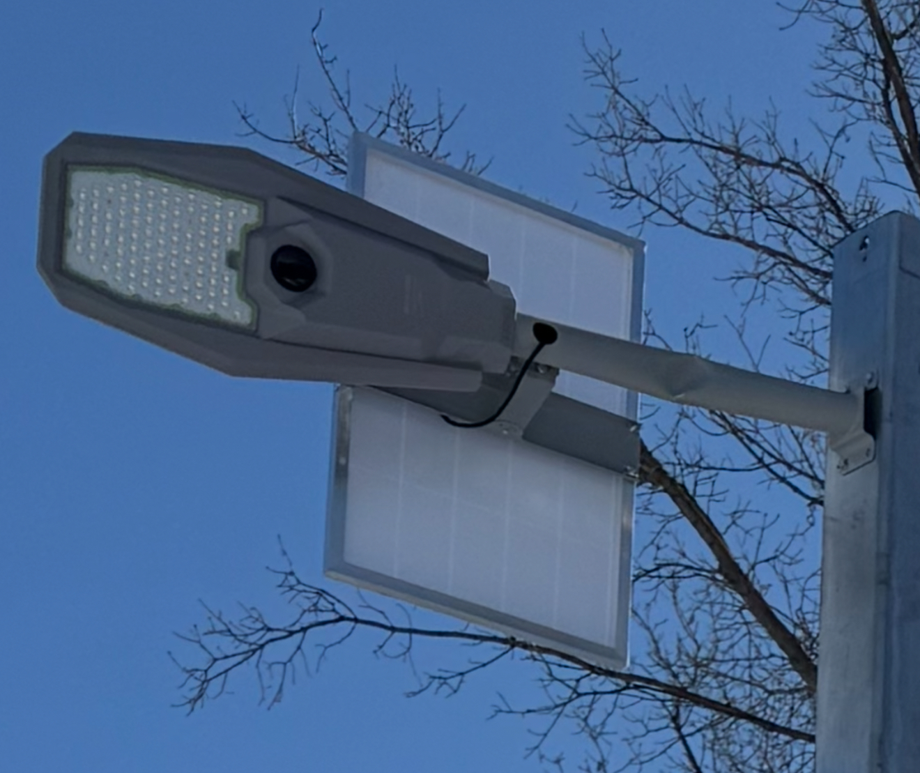 Close-up of a solar street light fixture showing the LED head and photovoltaic panel